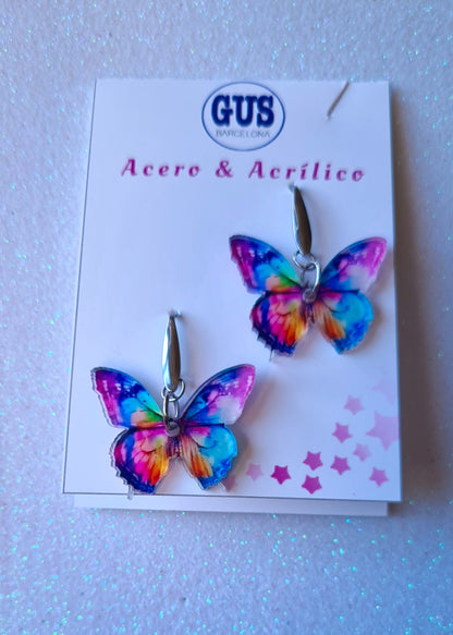Pendientes Mariposa multicolor para mujer en Acero y Acrílico. Posa sobre cartón blanco.