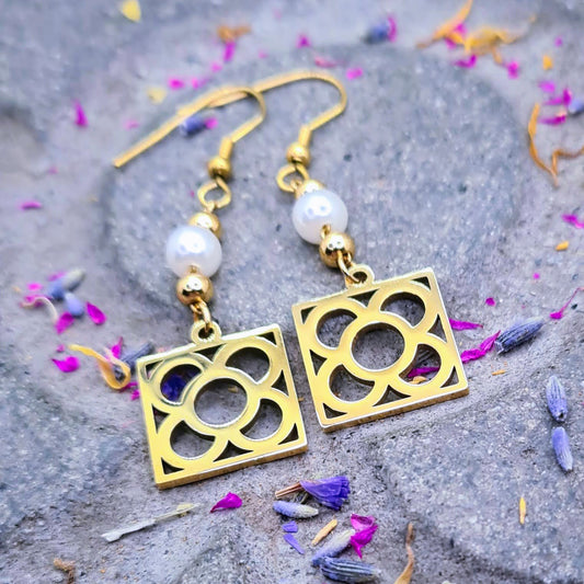Pendientes de perla con la Flor de Barcelona de acero inoxidable dorado, conocida también como la rajola o panot es uno de los símbolos de la ciudad de Barcelona.