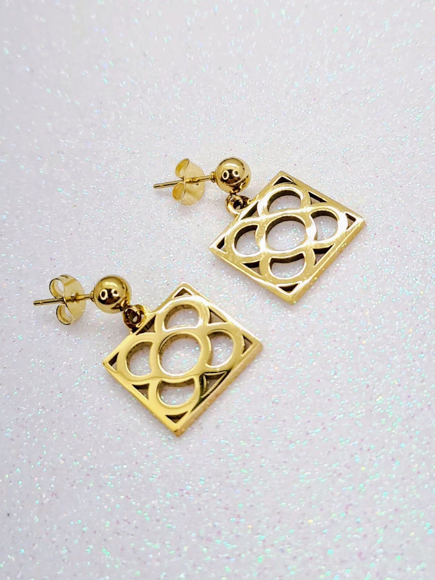Pendientes con la Flor de Barcelona de acero inoxidable dorado, conocida también como la rajola o panot es uno de los símbolos de la ciudad de Barcelona. Tope de Bola.