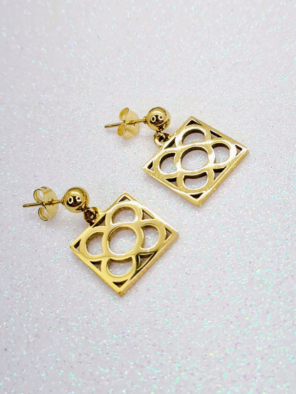 Pendientes con la Flor de Barcelona de acero inoxidable dorado, conocida también como la rajola o panot es uno de los símbolos de la ciudad de Barcelona. Tope de Bola.