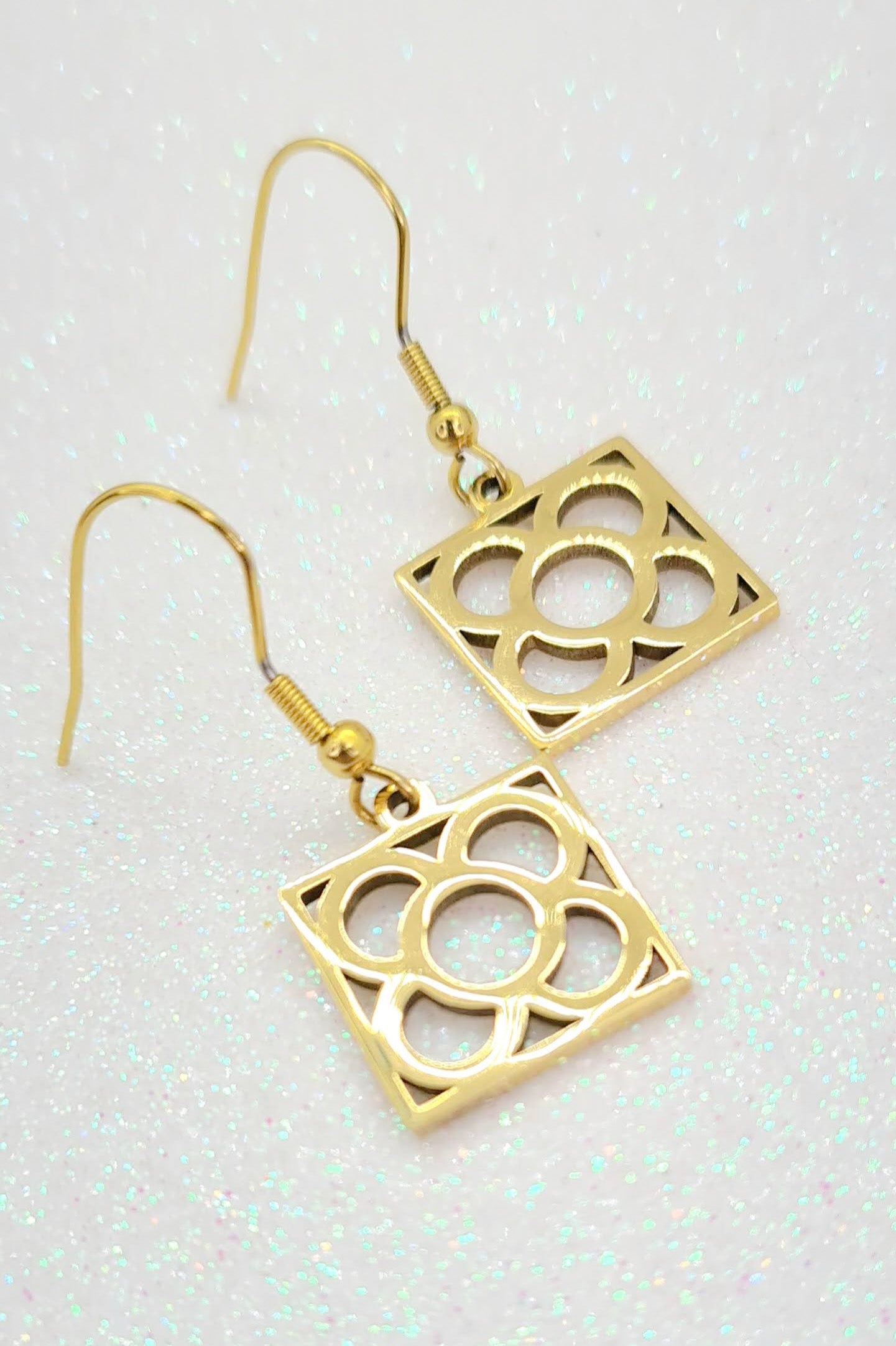 Pendientes con la Flor de Barcelona de acero inoxidable dorado, conocida también como la rajola o panot es uno de los símbolos de la ciudad de Barcelona. Gancho.