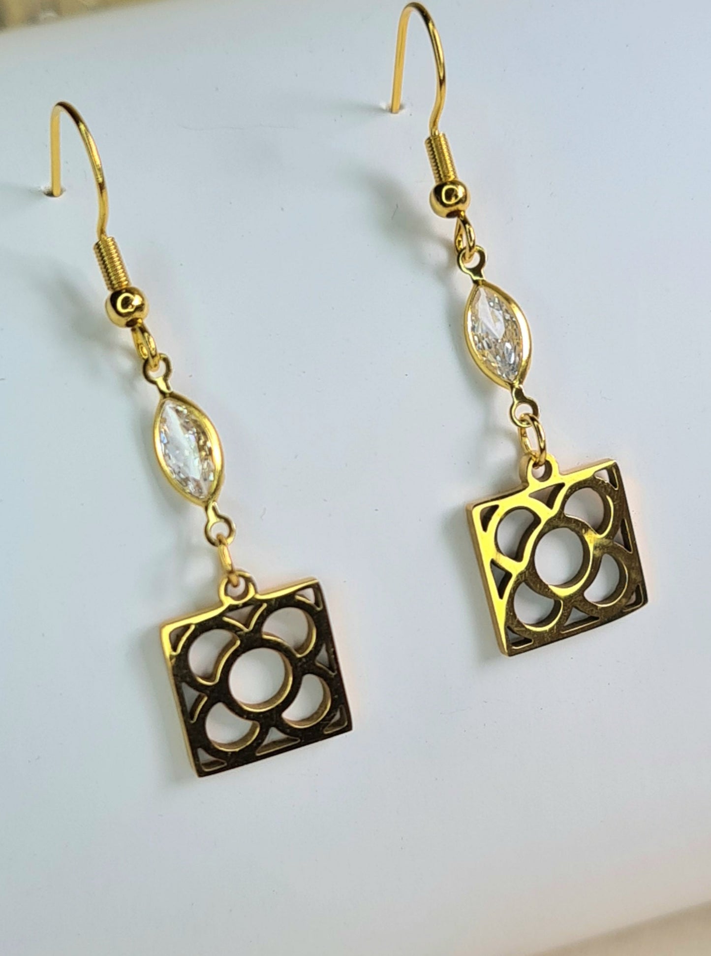 Pendientes de acero inoxidable dorado con la Flor de Barcelona y lagrimitas blancas para mujer.