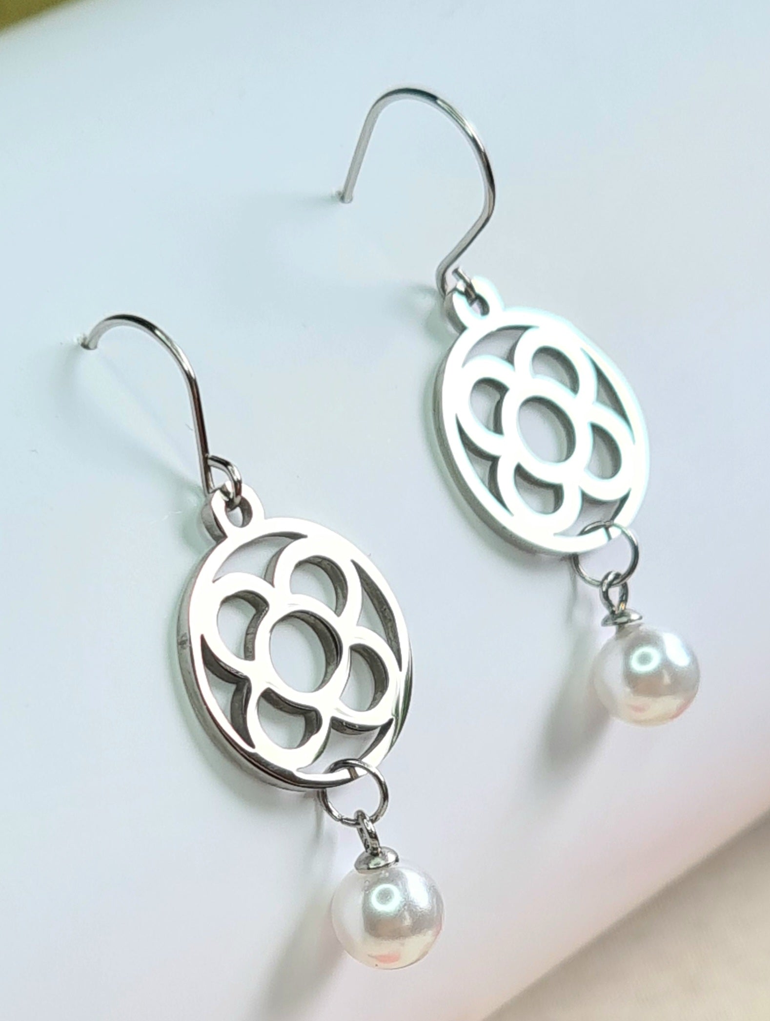 Pendientes de acero inoxidable plateado con la Flor de Barcelona circular y perla colgante para mujer.