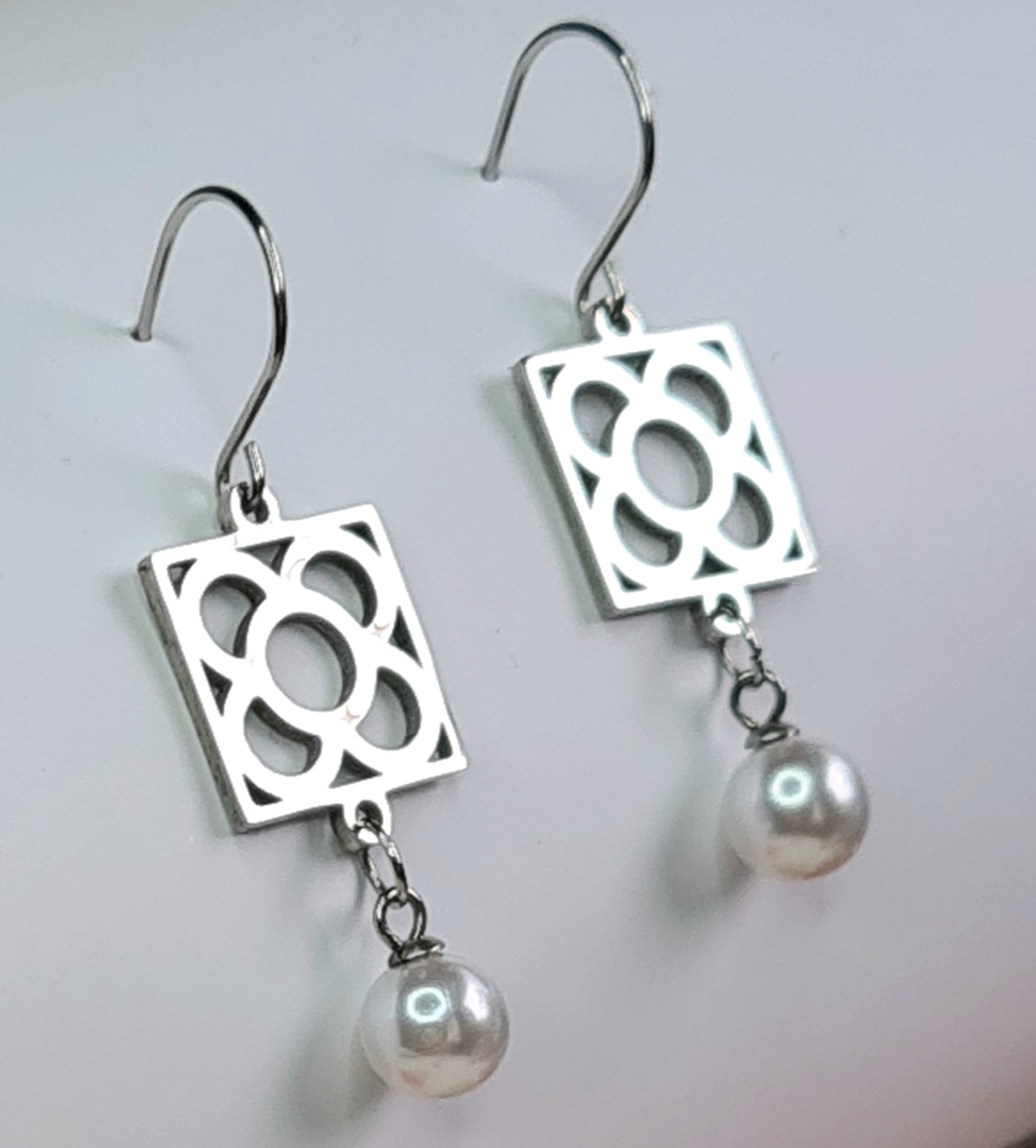Pendientes de acero inoxidable plateado con la Flor de Barcelona y perla colgante para mujer.