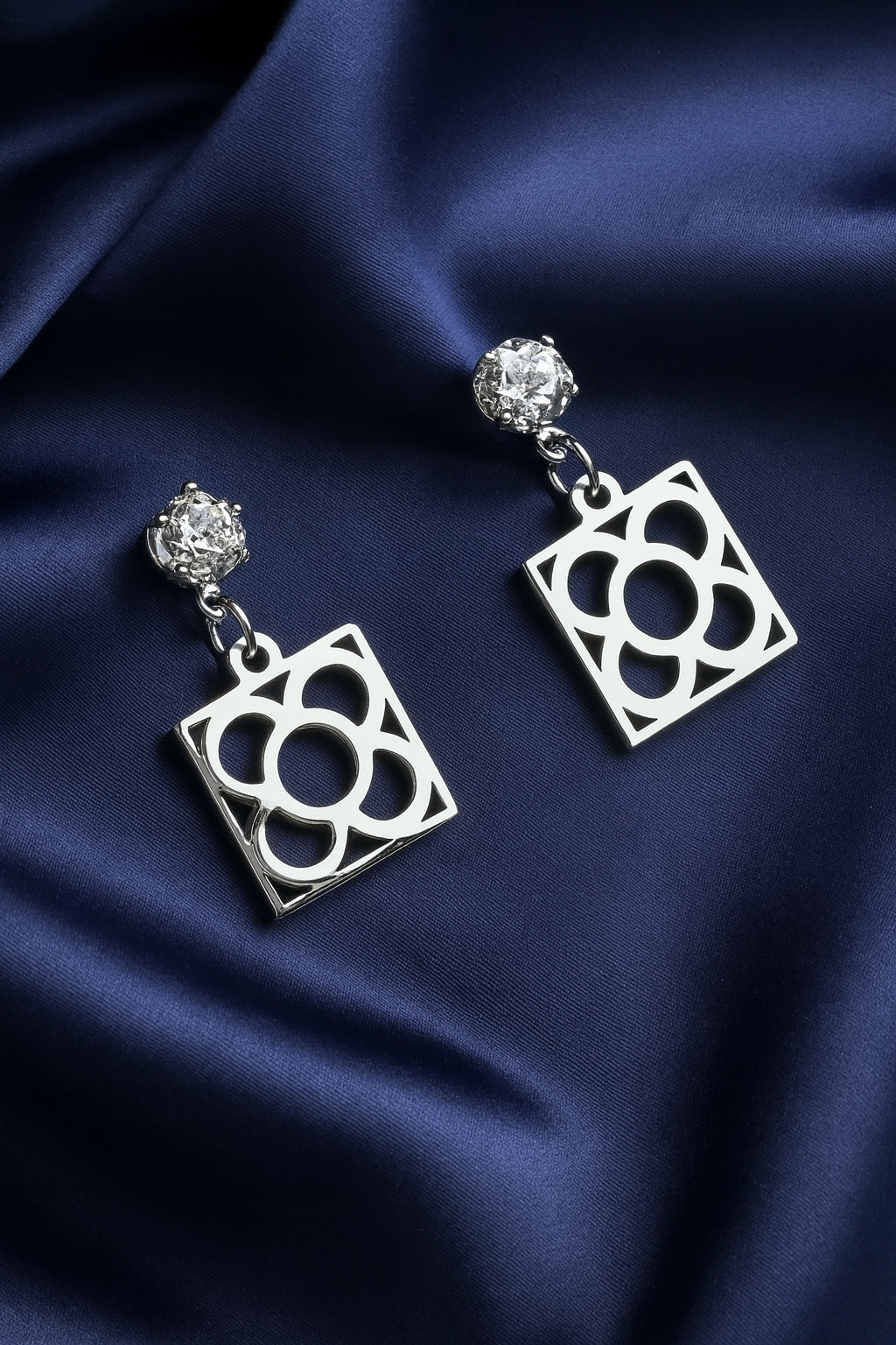 Pendientes de acero inoxidable plateado con tope de circonita blanca y la Flor de Barcelona para mujer.
