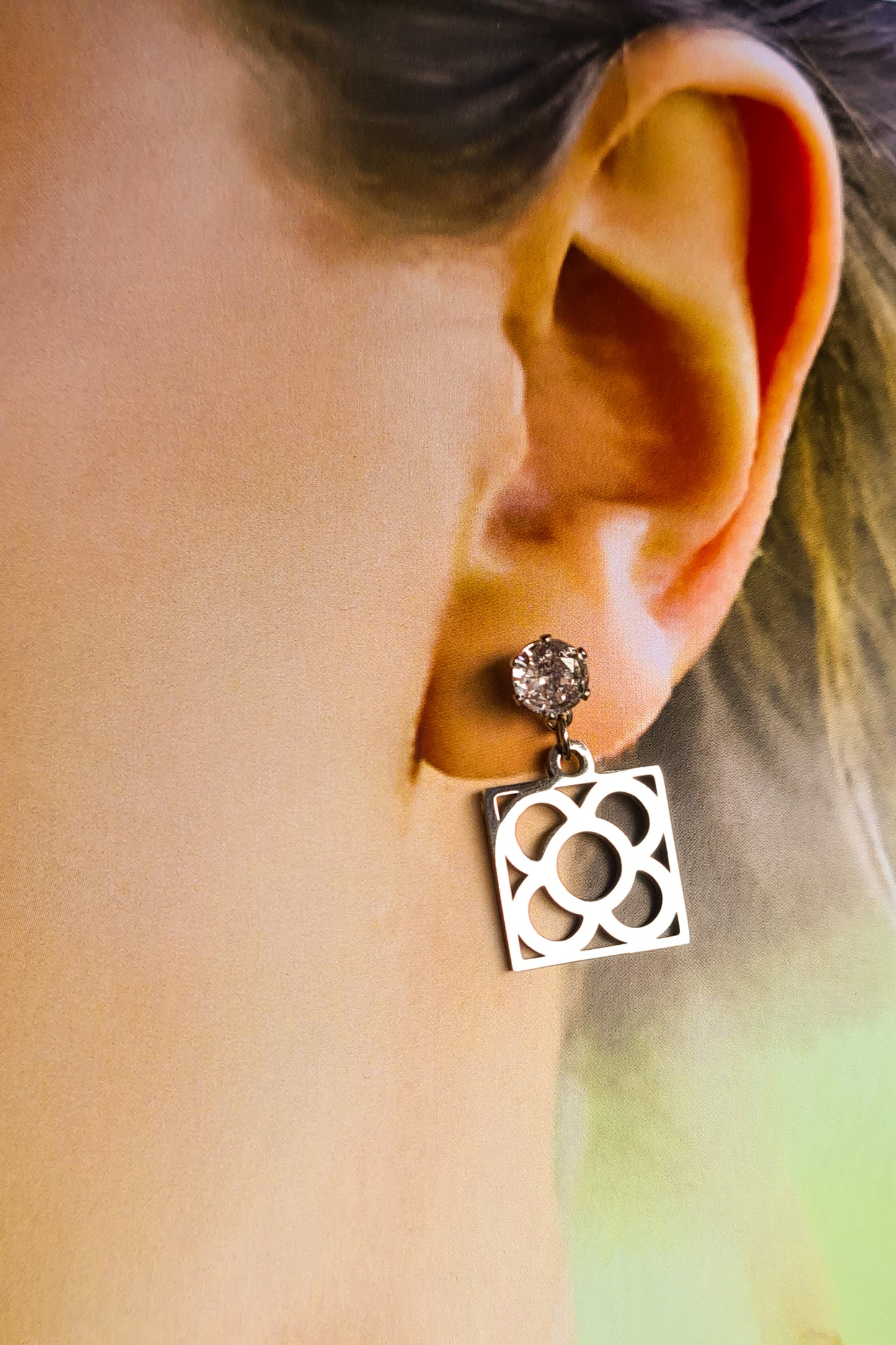 Pendientes de acero inoxidable plateado con tope de circonita blanca y la Flor de Barcelona para mujer.