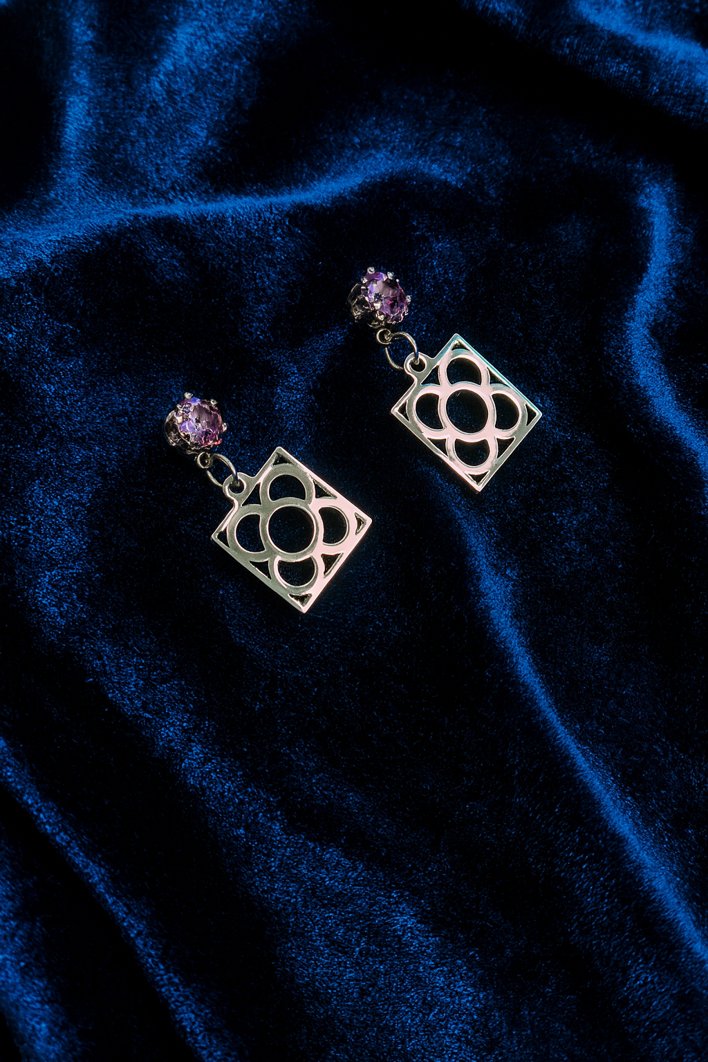 Pendientes de acero inoxidable plateado con tope de circonita lila y la Flor de Barcelona para mujer.