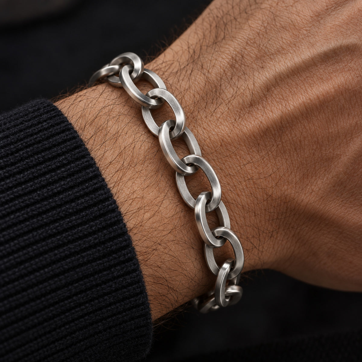 Pulsera masculina de acero inoxidable con eslabones elípticos llevada en la muñeca.