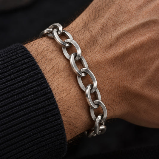 Pulsera masculina de acero inoxidable con eslabones elípticos llevada en la muñeca.