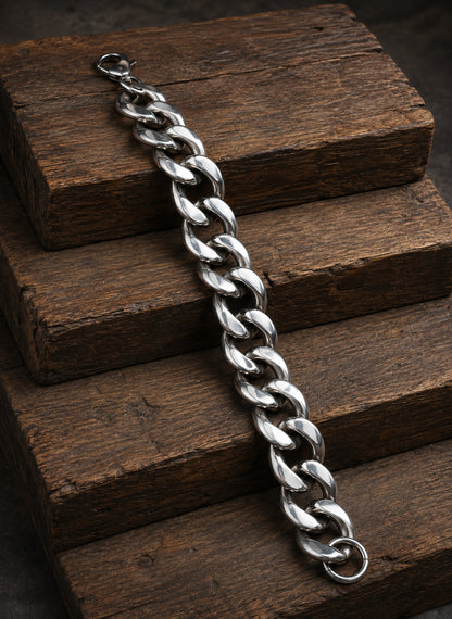 Pulsera masculina de acero inoxidable con eslabones anchos sobre madera rústica.
