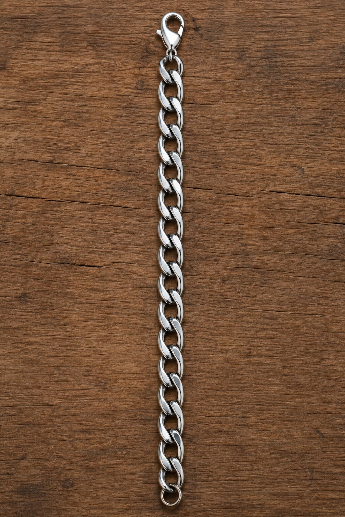 Pulsera masculina de acero inoxidable con eslabones de 10 mm extendida sobre madera.