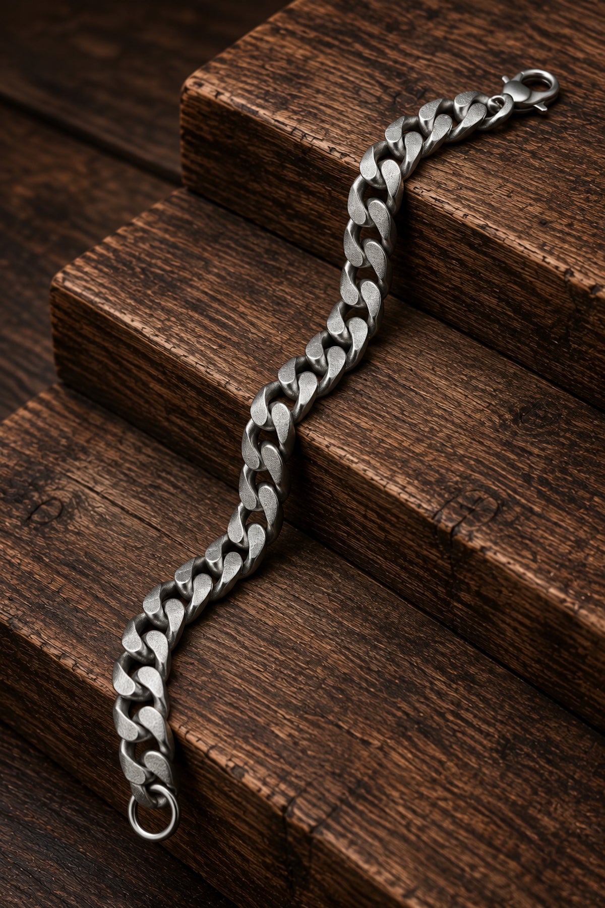 Pulsera de acero inoxidable con acabado mate presentada sobre madera oscura.