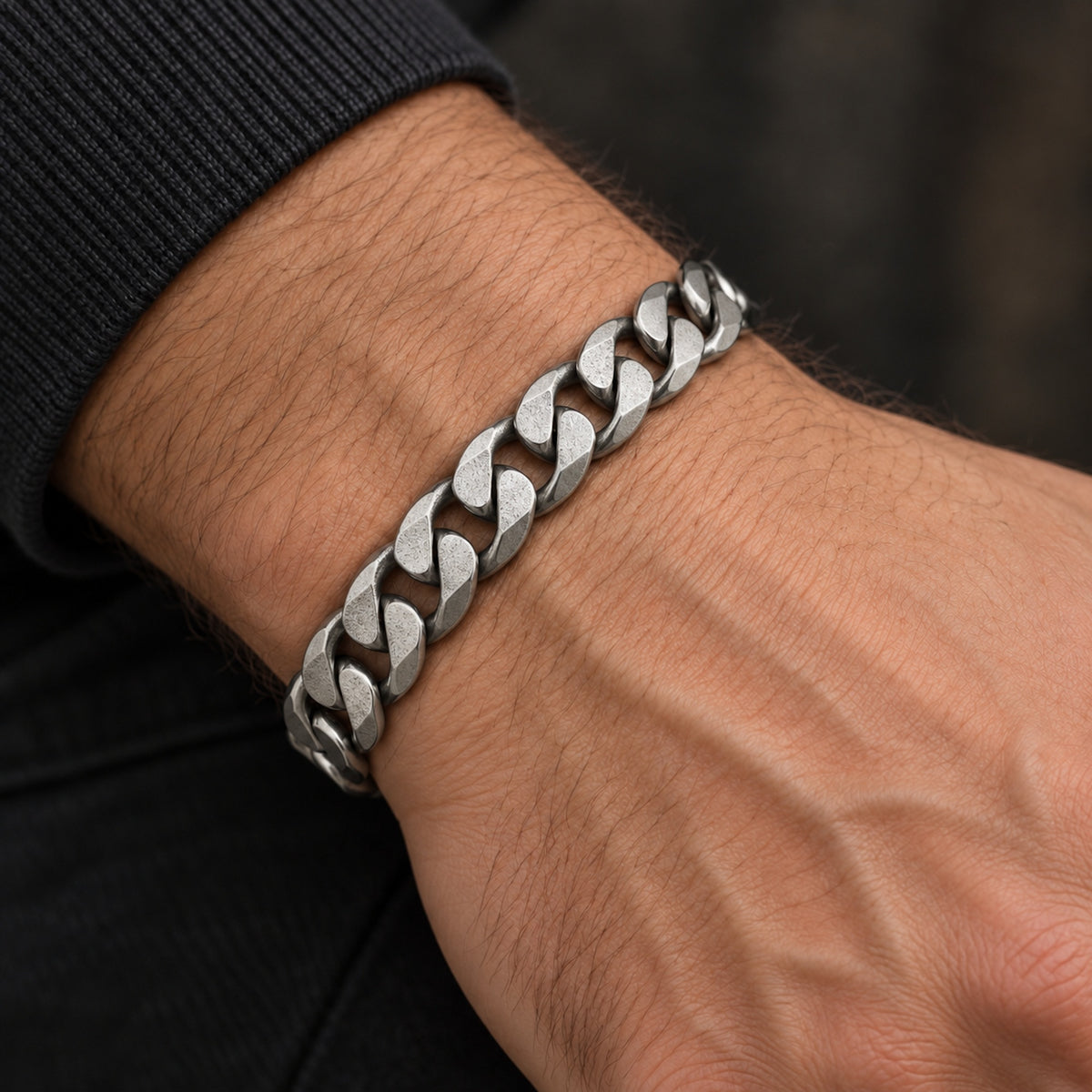 Pulsera masculina de acero inoxidable mate llevada en la muñeca.
