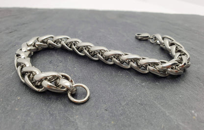 Pulsera acero inoxidable modelo Trenzado, 10mm de ancho. Posa sobre pizarra.