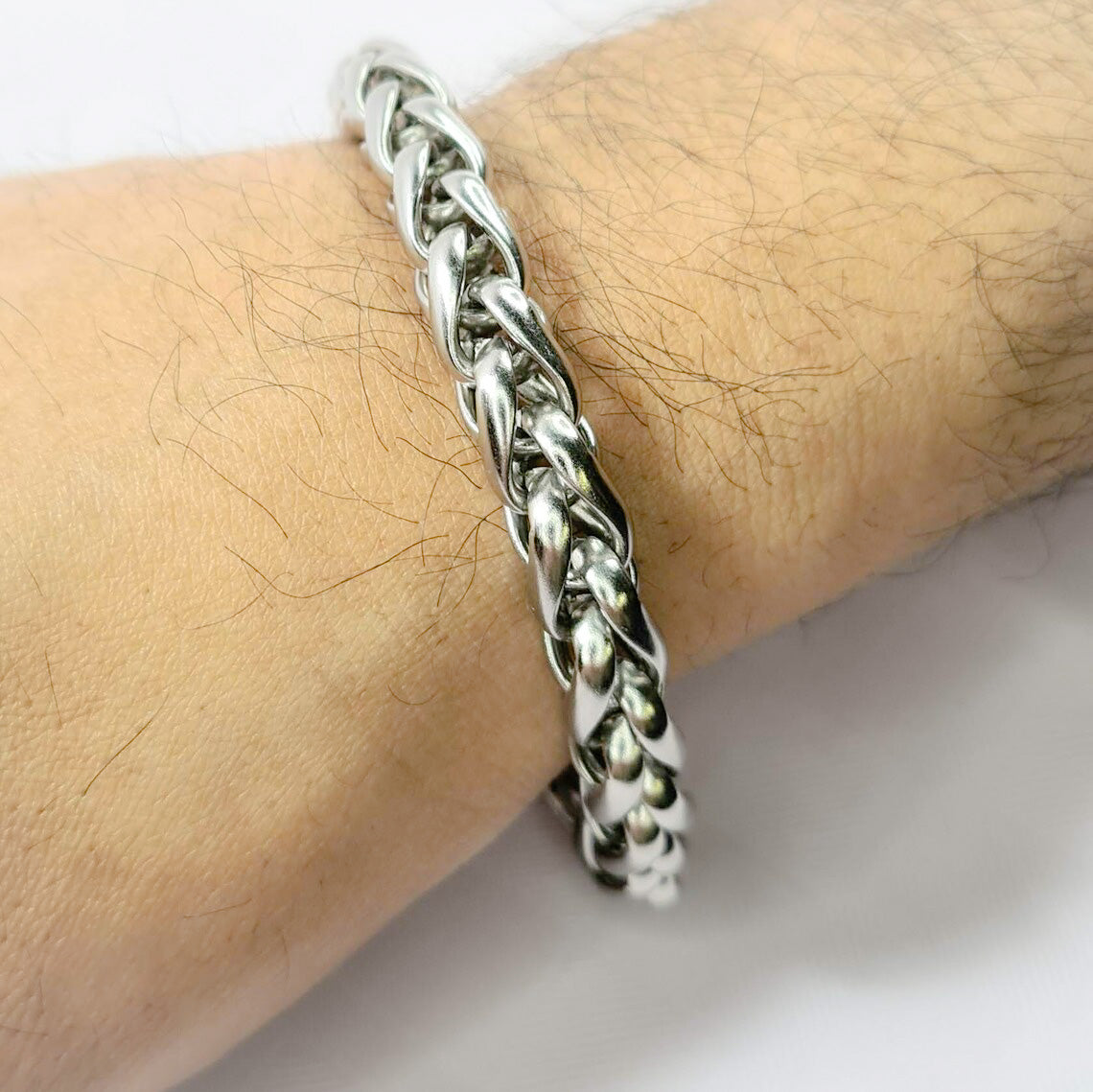 Pulsera acero inoxidable modelo Trenzado, 10mm de ancho. Posa sobre mano de modelo.