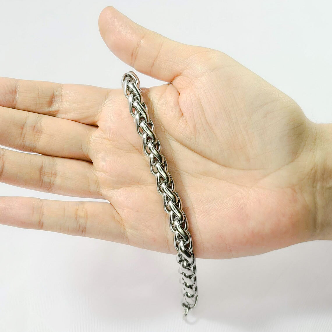 Pulsera acero inoxidable modelo Trenzado, 10mm de ancho. Posa sobre mano de modelo.