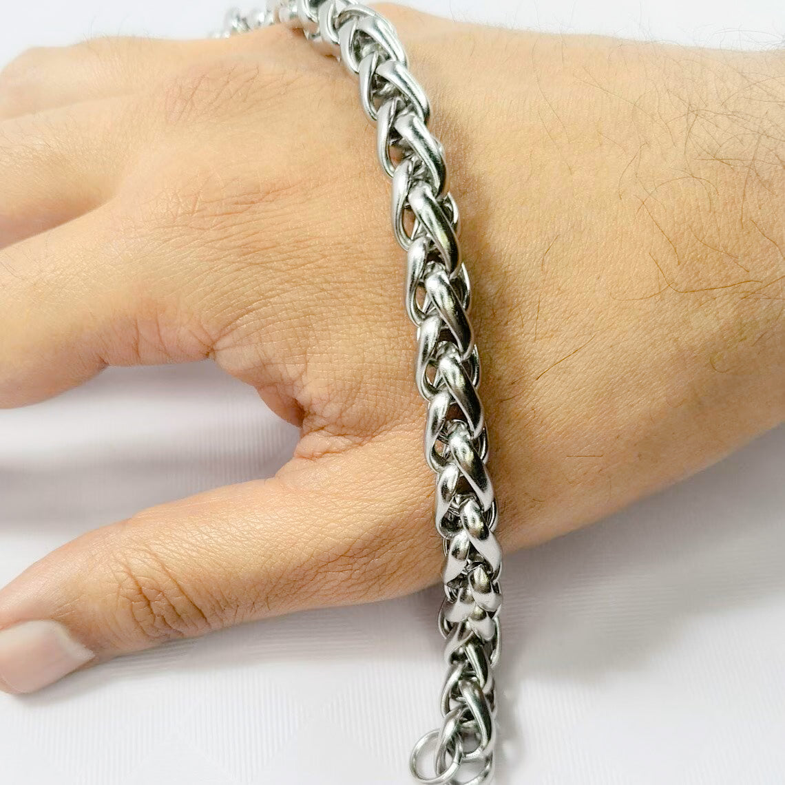 Pulsera acero inoxidable modelo Trenzado, 10mm de ancho. Posa sobre mano de modelo.