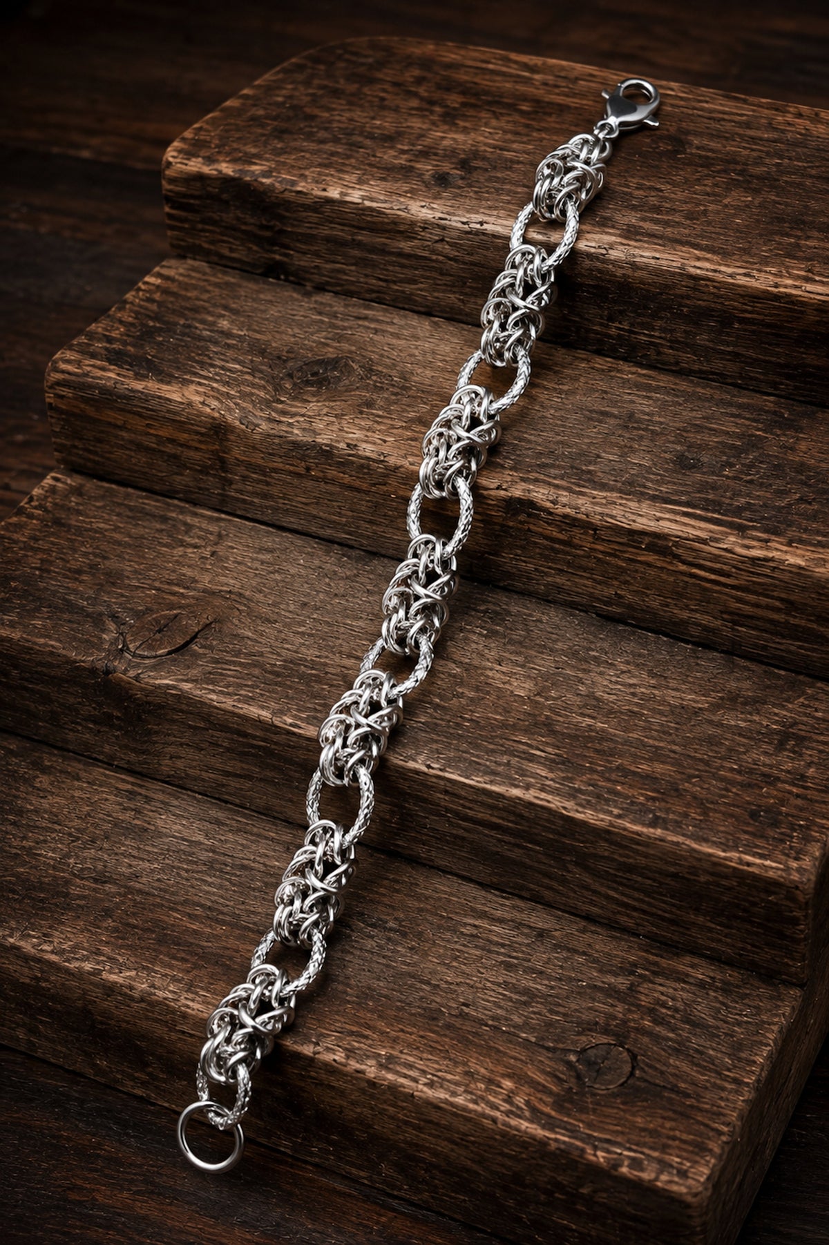 Pulsera 9mm de acero inoxidable con diseño trenzado presentada sobre madera oscura.