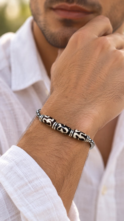 Pulsera artesanal de hueso de yak y cadena de bolas llevada en la muñeca de un hombre.
