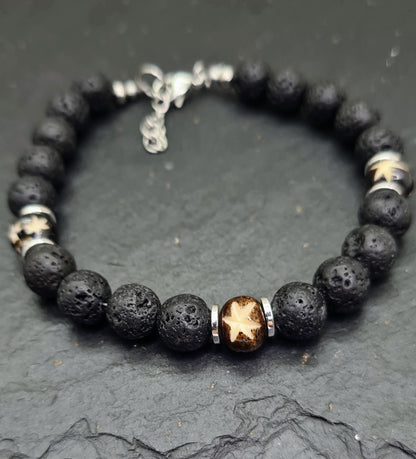 Pulsera masculina de lava volcánica negra con cuentas talladas de hueso de yak y detalles metálicos.
