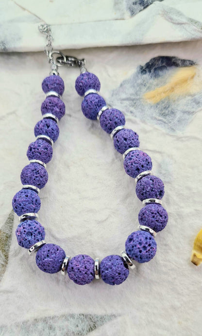 Pulsera de lava lila con cuentas redondas y discos plateados.
