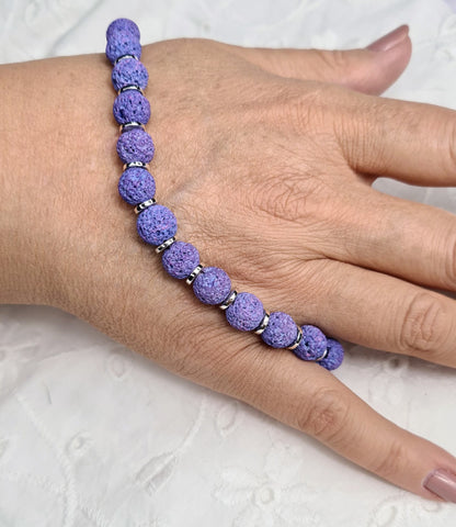 Pulsera de lava lila con cuentas redondas y discos plateados.