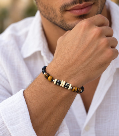 Hombre llevando pulsera artesanal de ónix facetado, ojo de tigre y hueso tallado.
