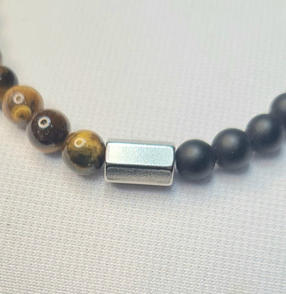 Detalle de pulsera de ojo de tigre y ónix negro mate.