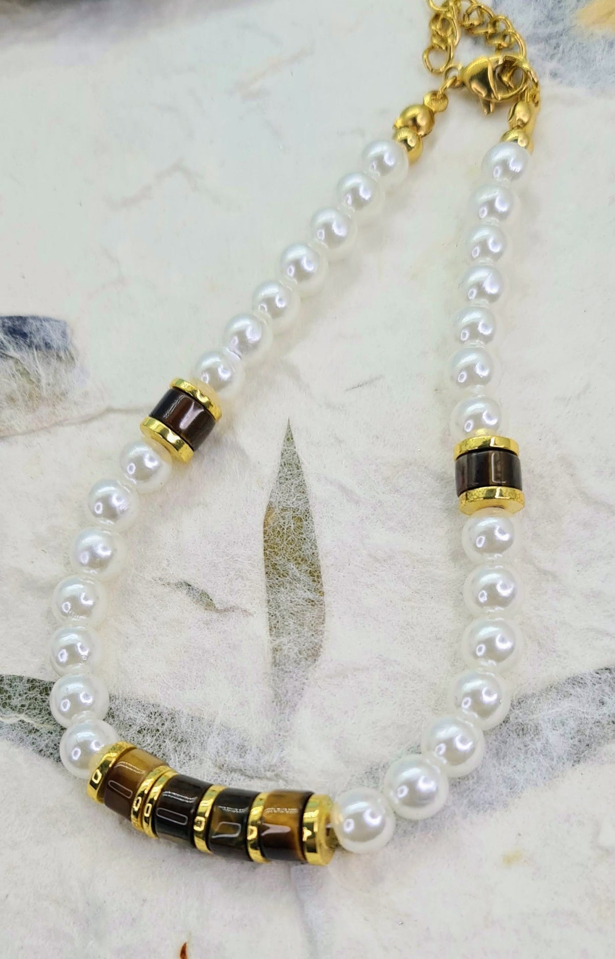 Pulsera completa de perlas blancas con ojo de tigre y detalles dorados.