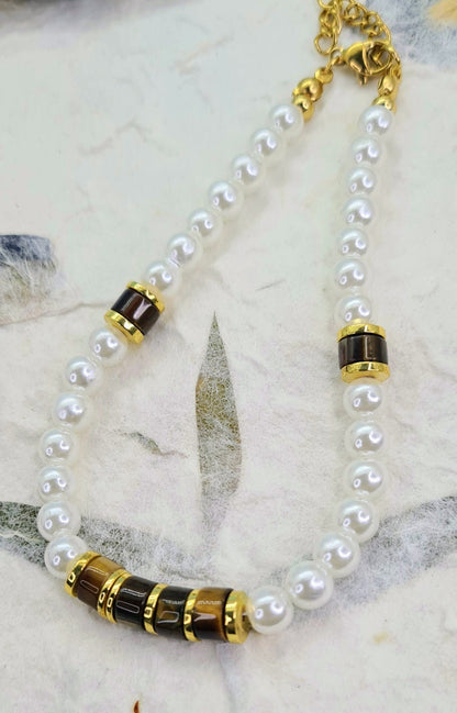 Pulsera completa de perlas blancas con ojo de tigre y detalles dorados.