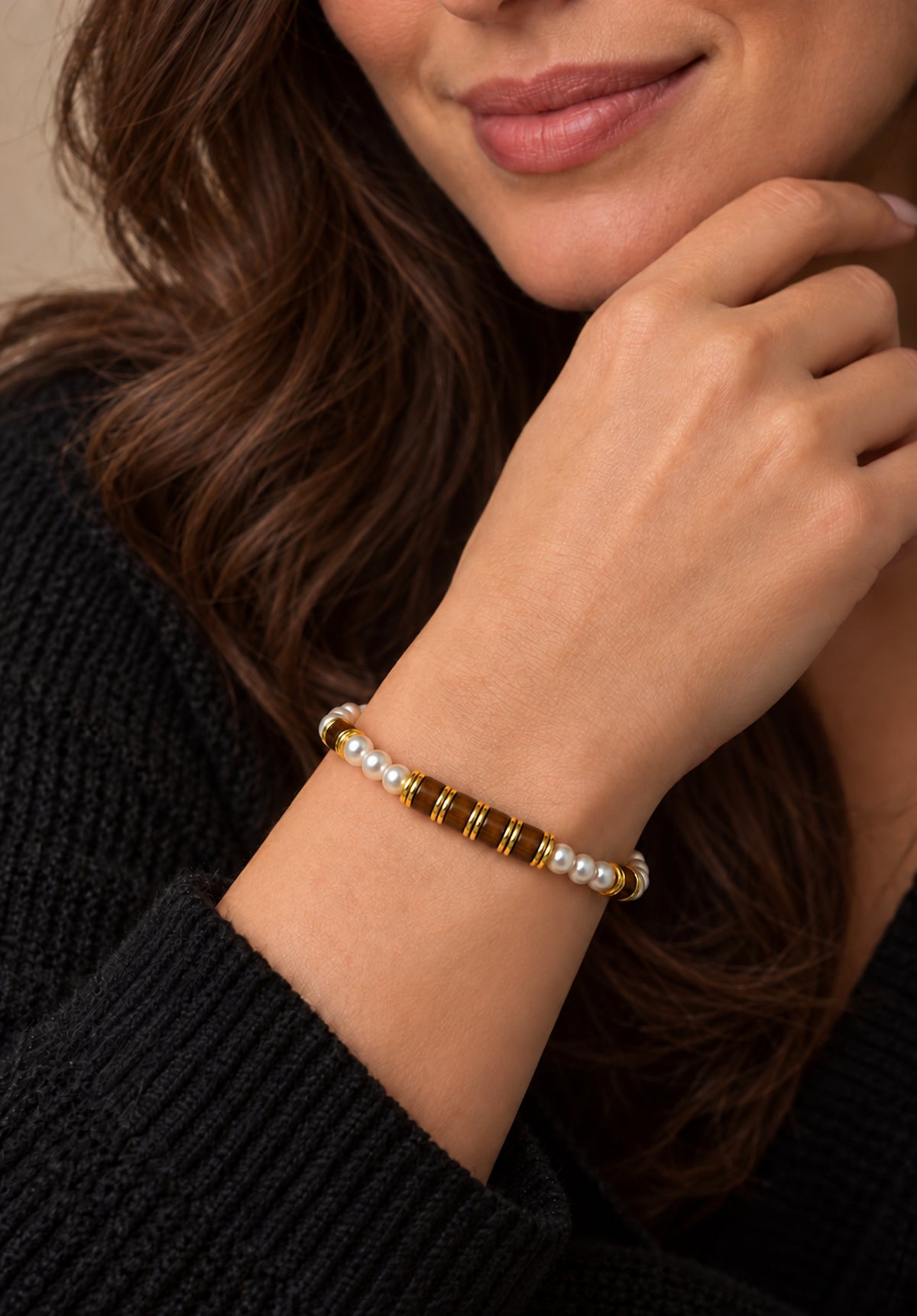Pulsera de perlas y ojo de tigre llevada en la muñeca.