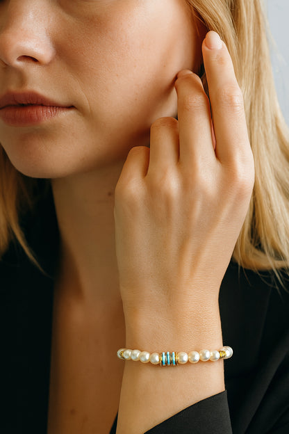 Pulsera de perlas con discos verdes y dorados puesta en la muñeca.