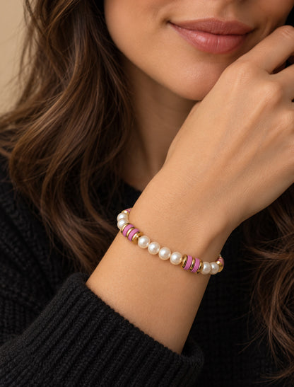 Pulsera de perlas con discos rosa y detalles dorados puesta en una mujer.
