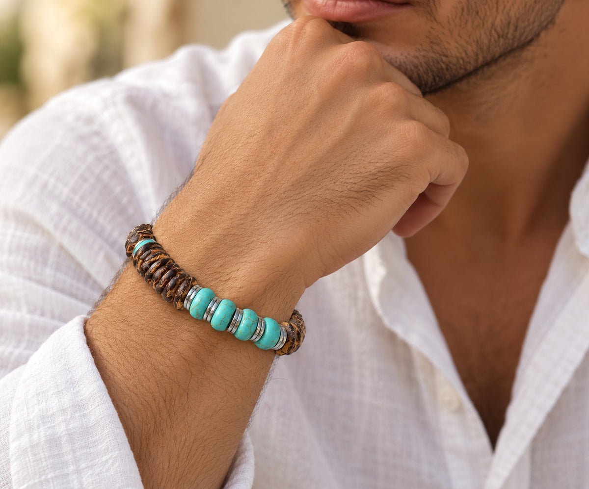 Hombre llevando pulsera de rondeles de coco y turquesa con separadores metálicos.