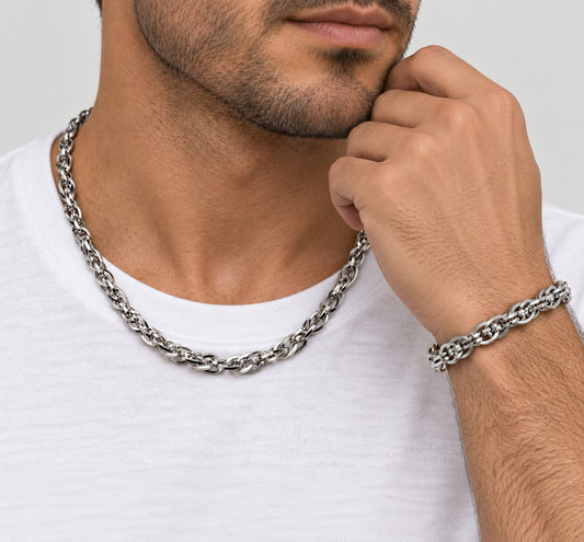 Hombre con cadena trenzada de acero al cuello y pulsera a juego en la muñeca.